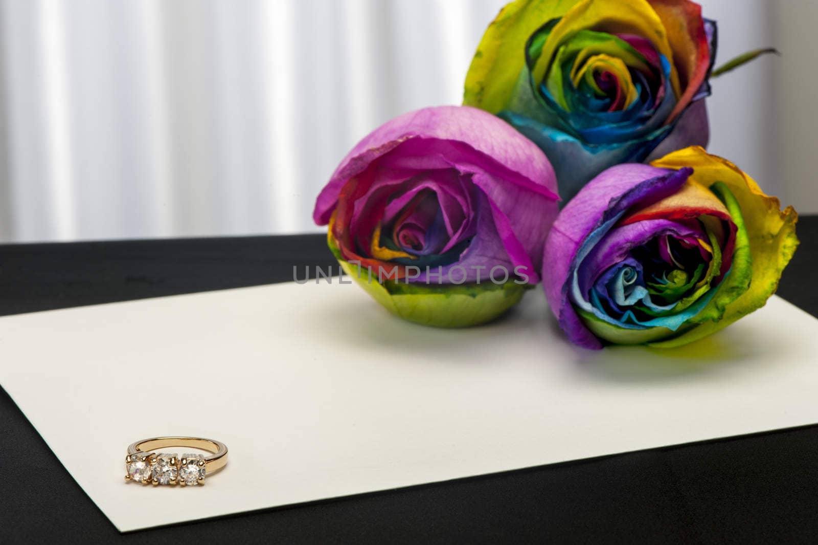a  roses and wedding rings on white background