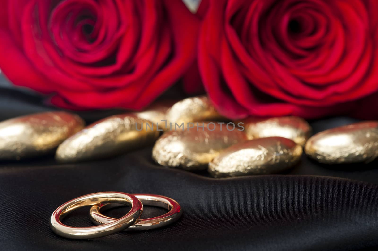 a  candy, roses and gold wedding rings 
