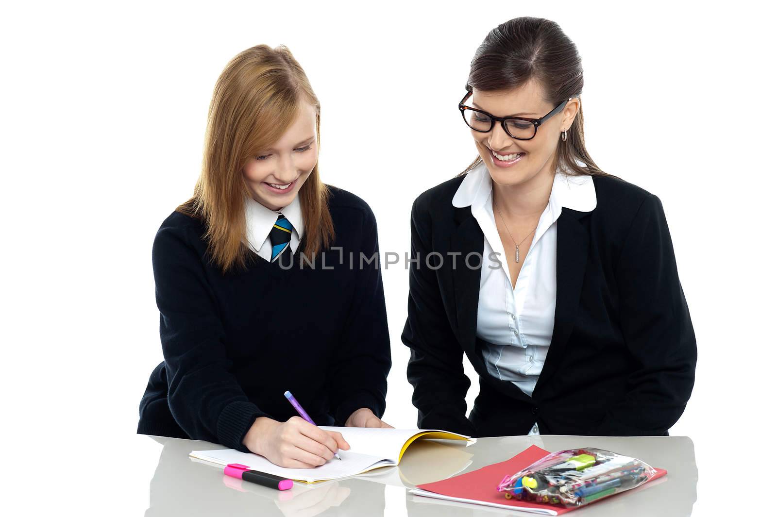 Teacher assisting schoolgirl in her homework