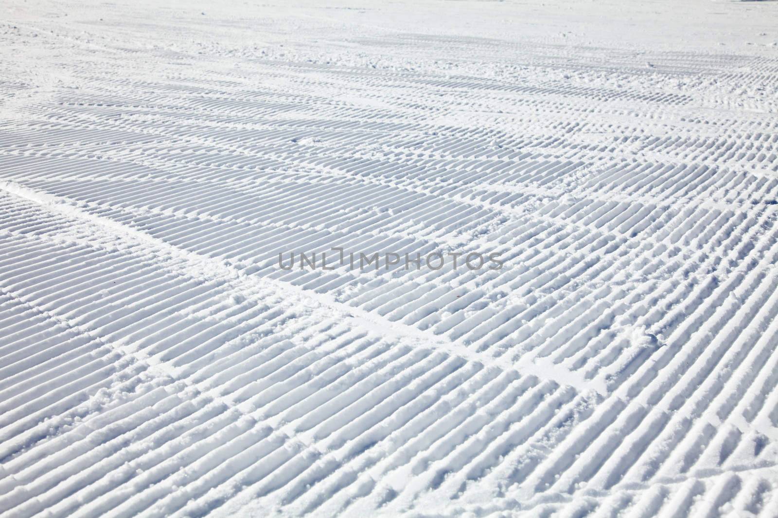 Ski tracks on a fresh groomed piste