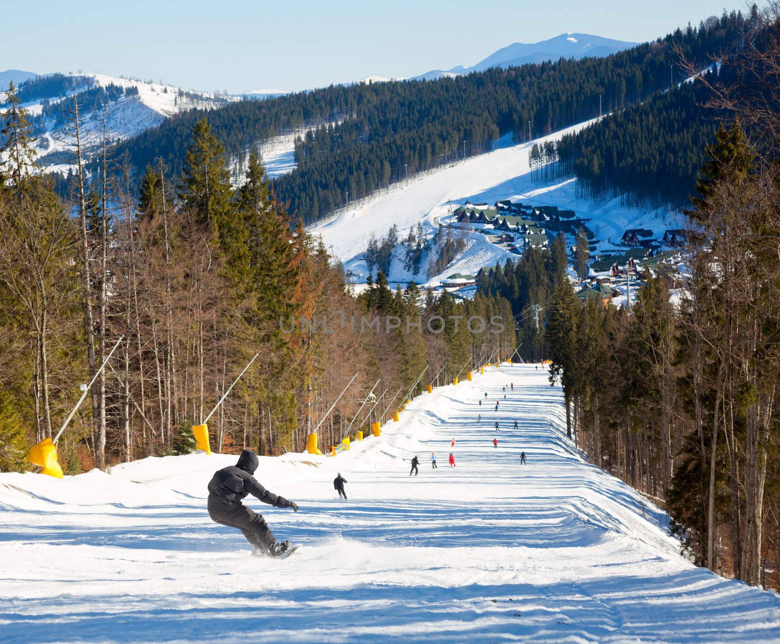 Snowborder going down the slope at ski resort
