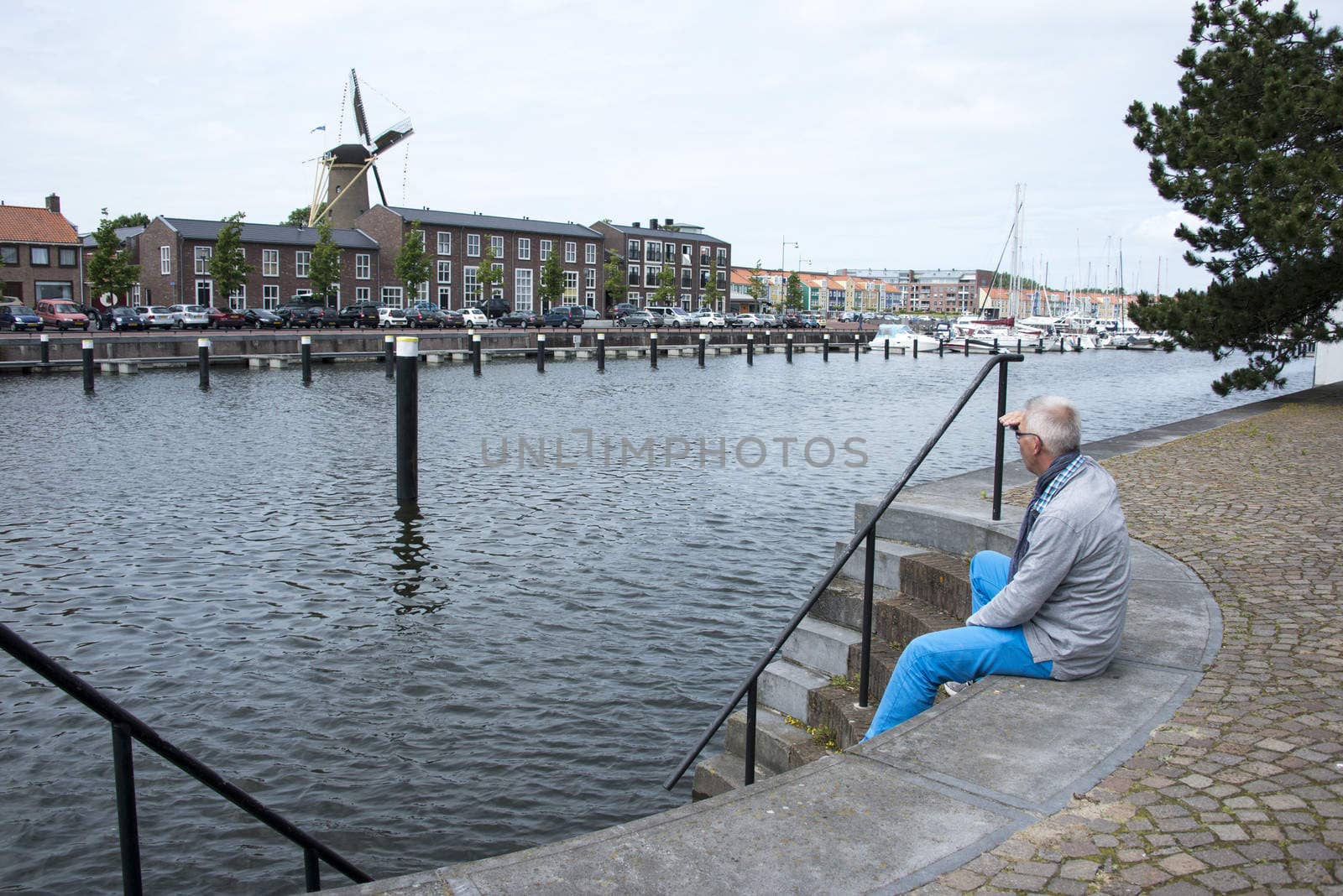 man sitting on the strairs to the water and thinking