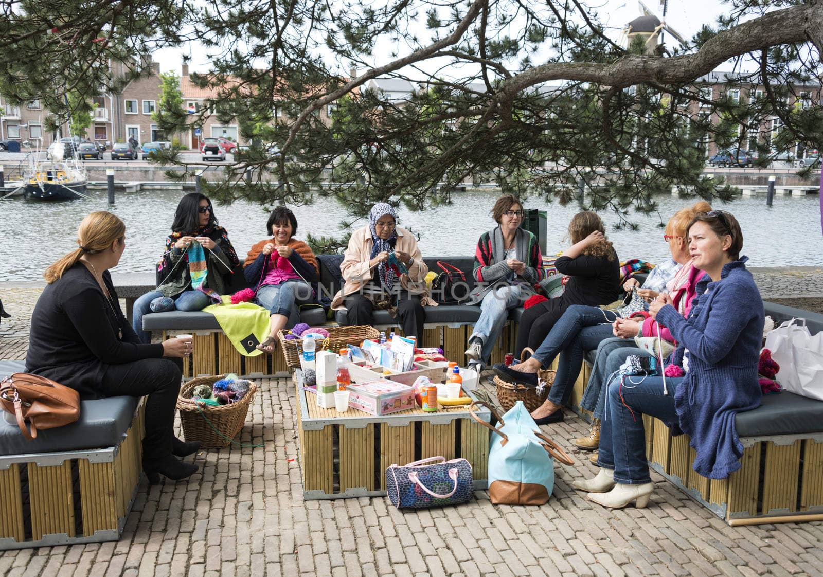HELLEVOETSLUIS,HOLLAND - JUNE 29:Unidentified woman knitting on a sofa outside,on June 29,2013 in Hellevoetsluis,Holland.This days is once a year to introduce art and culture