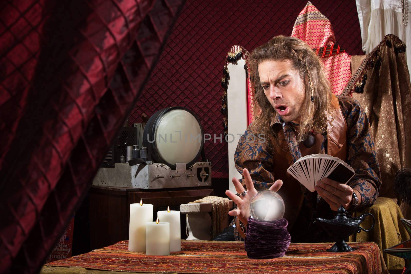 Male fortune teller concentrating on his crystal ball