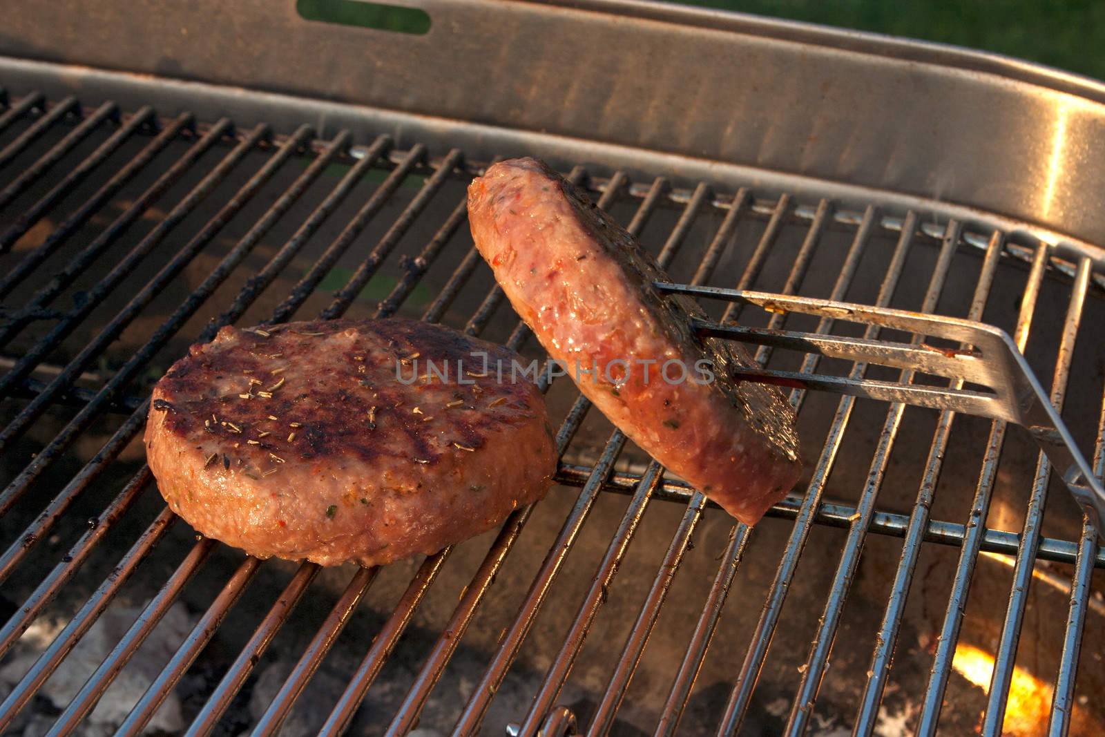 Cooking a few Hamburgers on a Barbecue outside in the garden