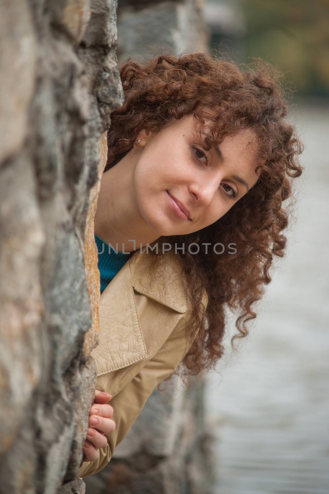 Beautiful sexy brunette girl poses near stone wall by kozak