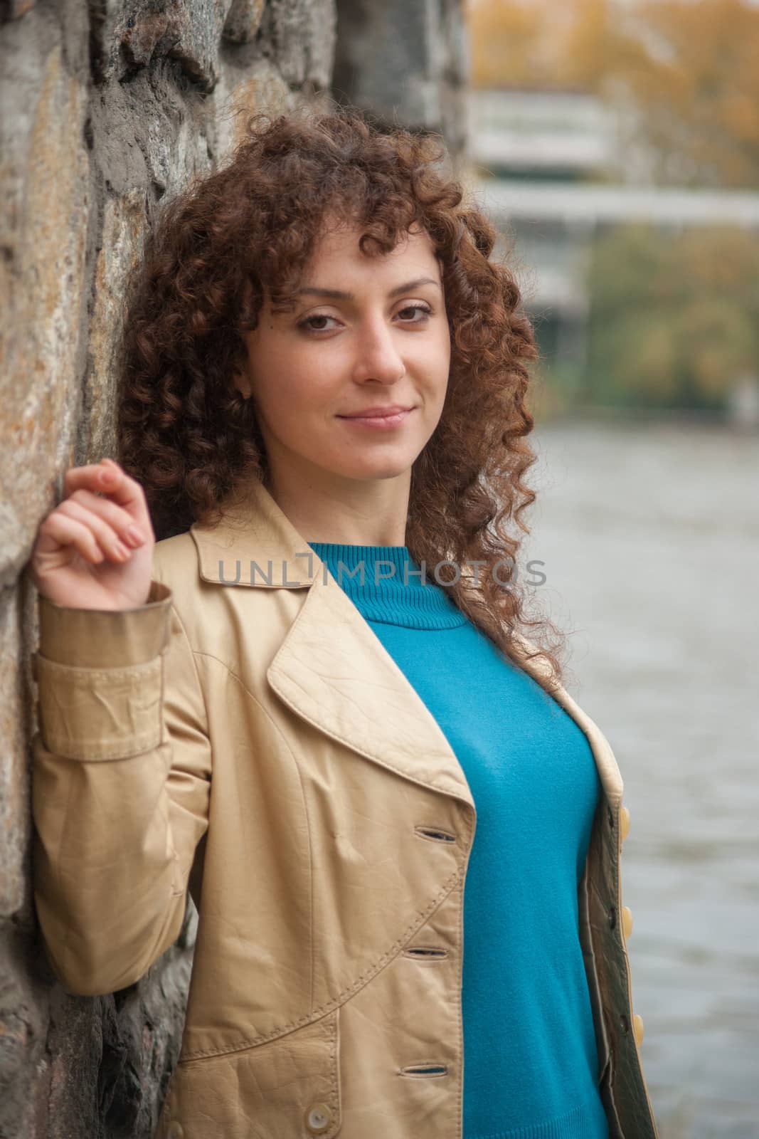 Beautiful sexy brunette girl poses near stone wall by kozak