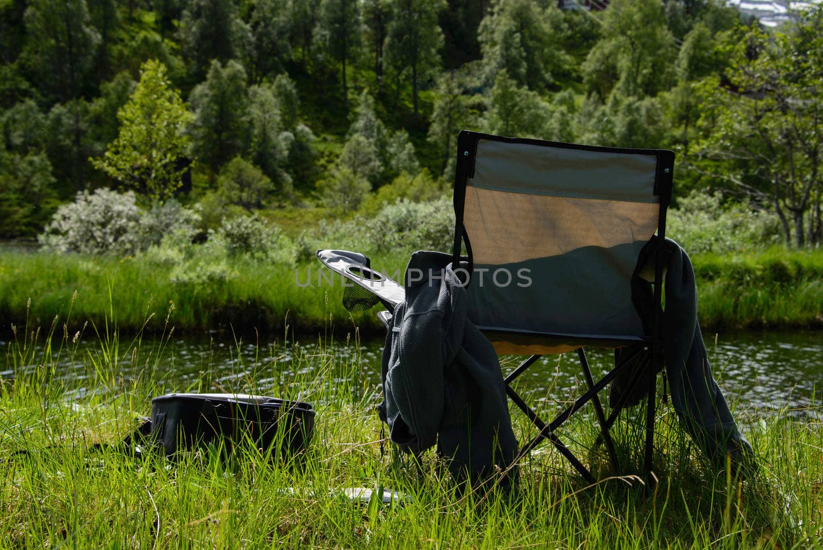 A folding fishermans`s chair by a river