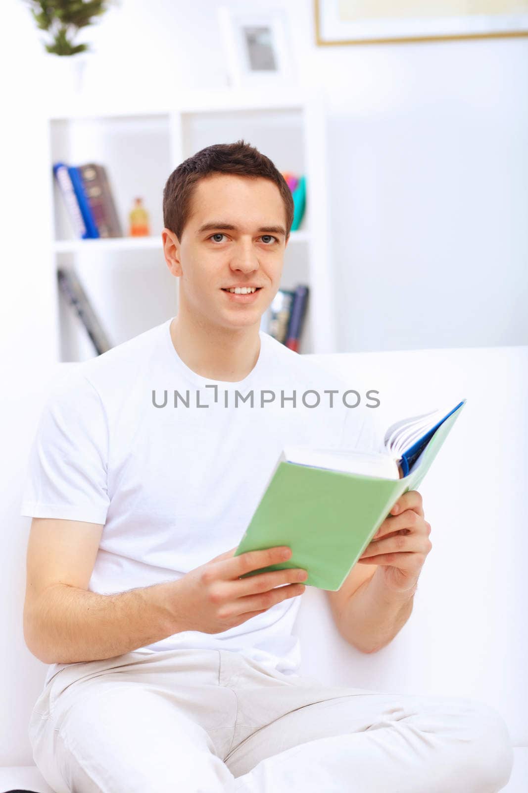 Young man at home with a book by sergey_nivens