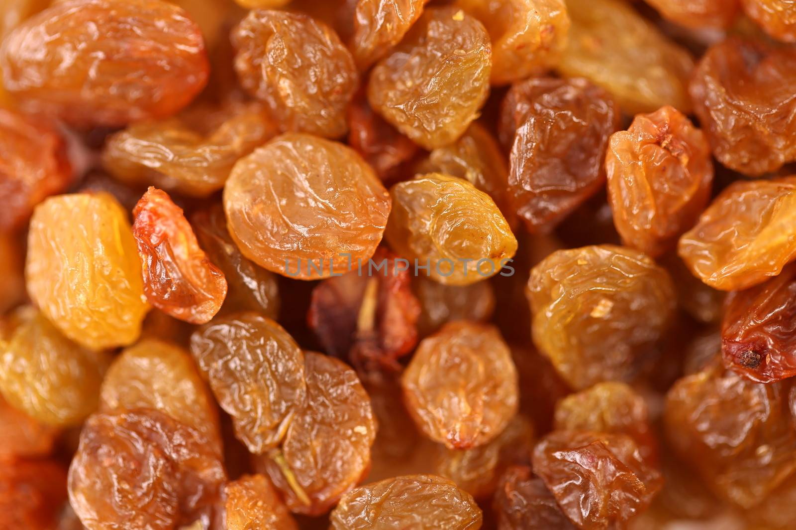Golden raisins background by indigolotos