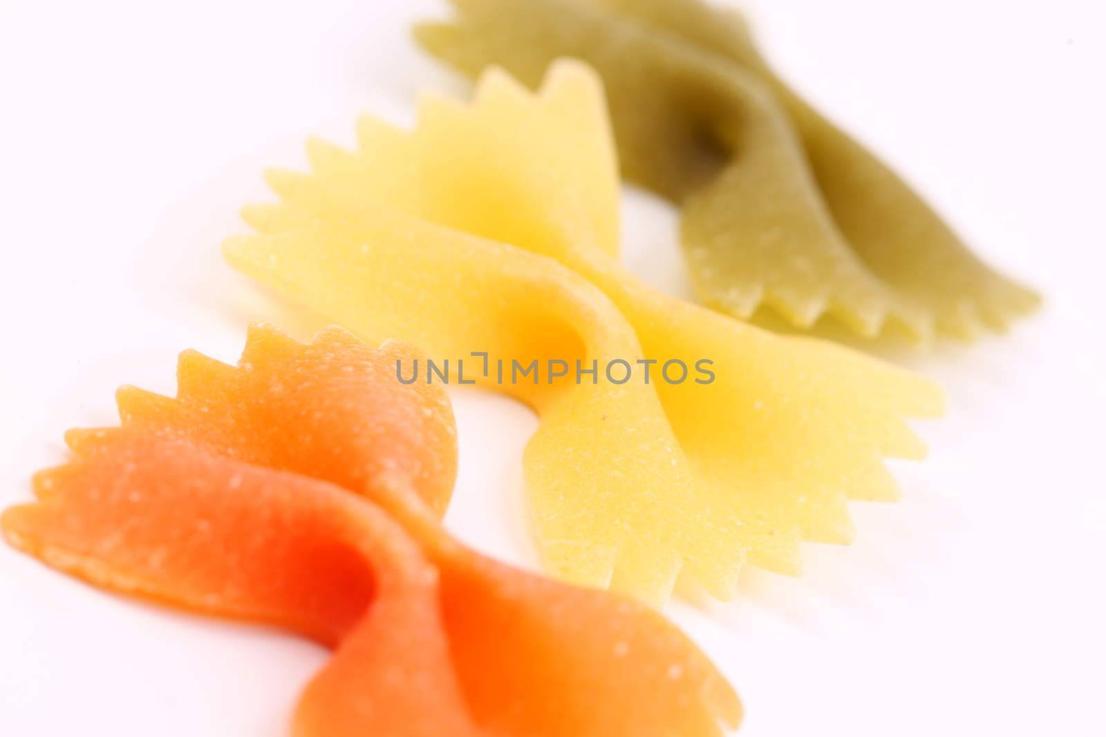 Close-up pasta farfalle three colors are located on the white background.