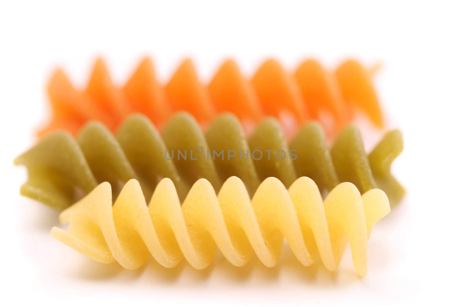 Close-up pasta eliche tricolori are located on the white background.