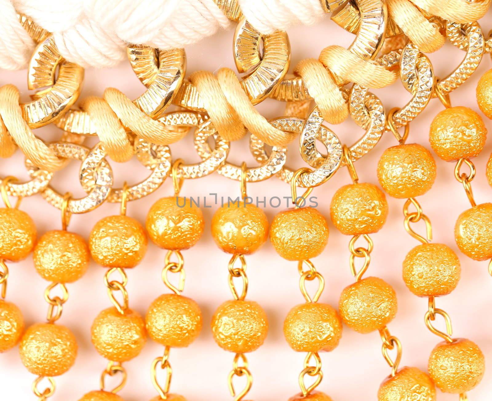 Golden pearls with macrame close-up on a whole background