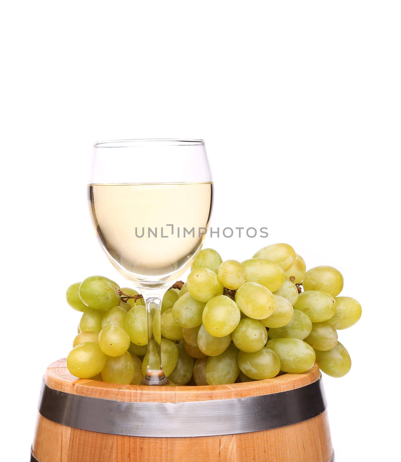 Ripe grapes and wine glass on a wooden vintage barrel isolated on a white background