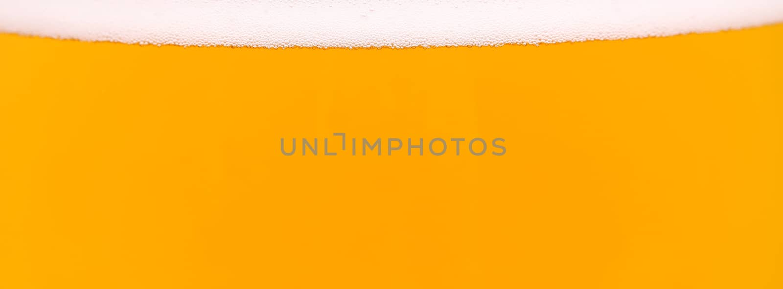 Light beer background. Is a thin strip of foam on top