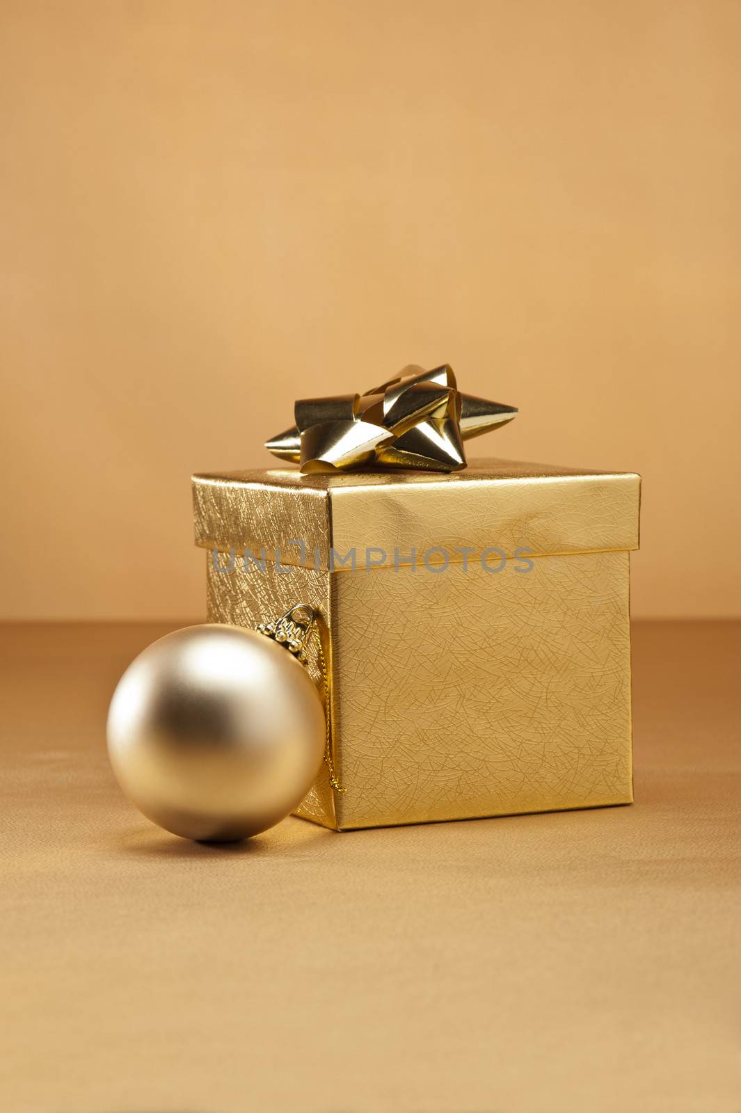 Gold bauble and present in Christmas setting