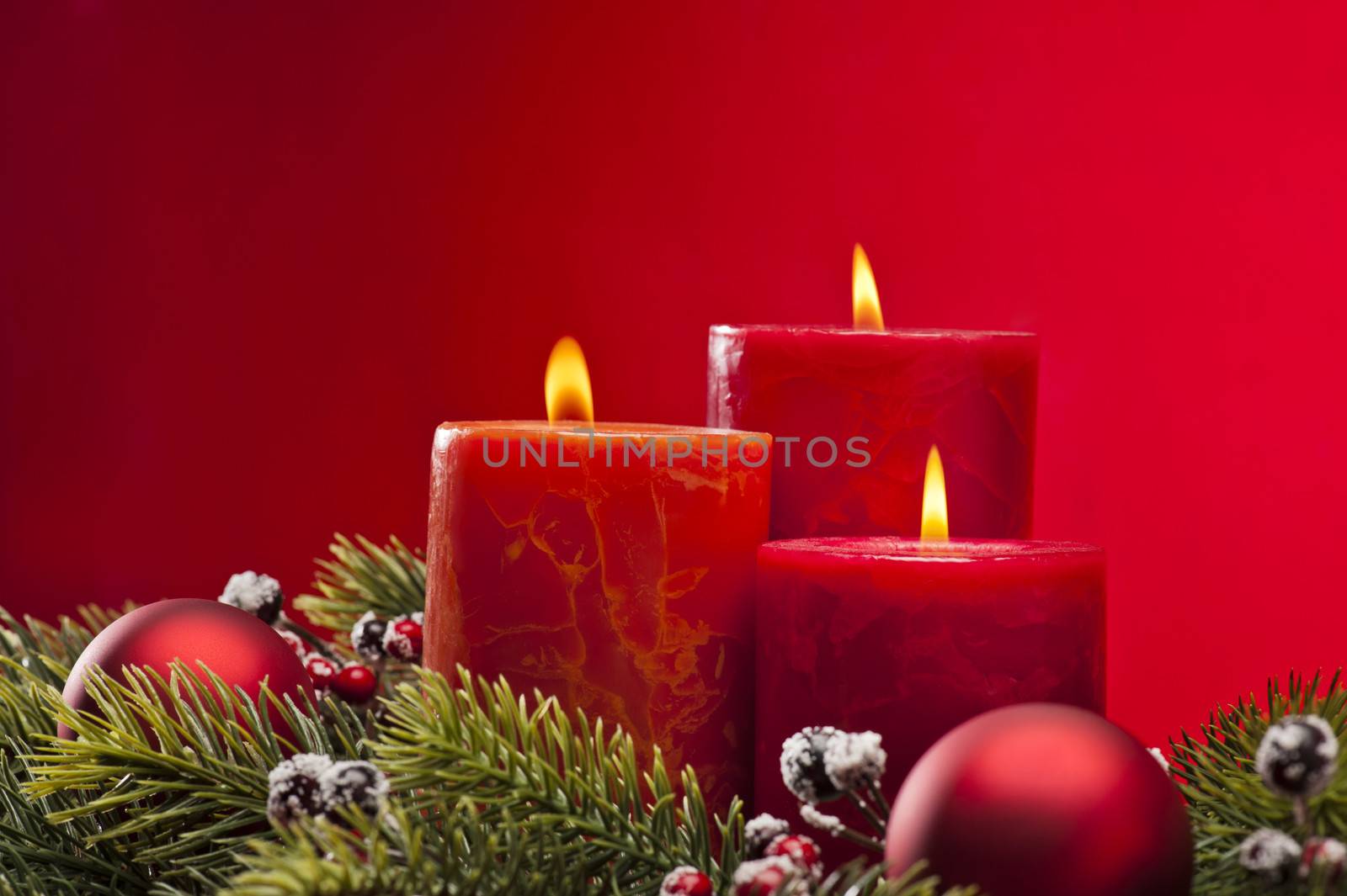 Red advent flower arrangement with burning candles