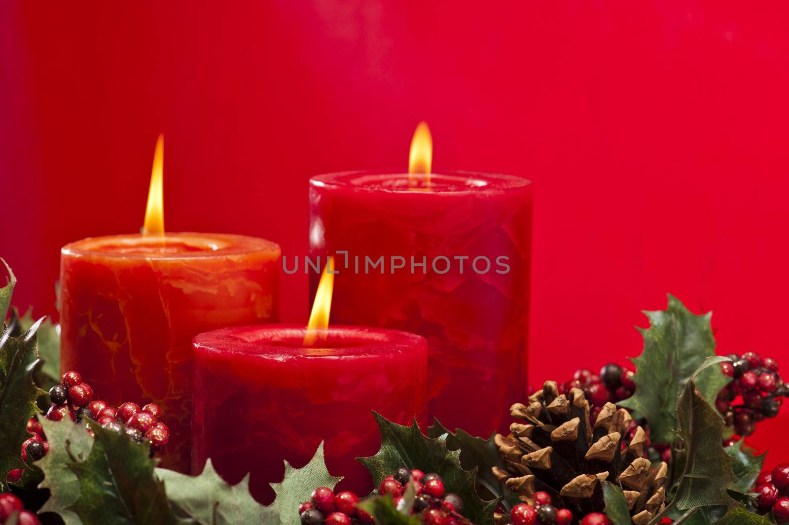 Red advent flower arrangement with burning candles