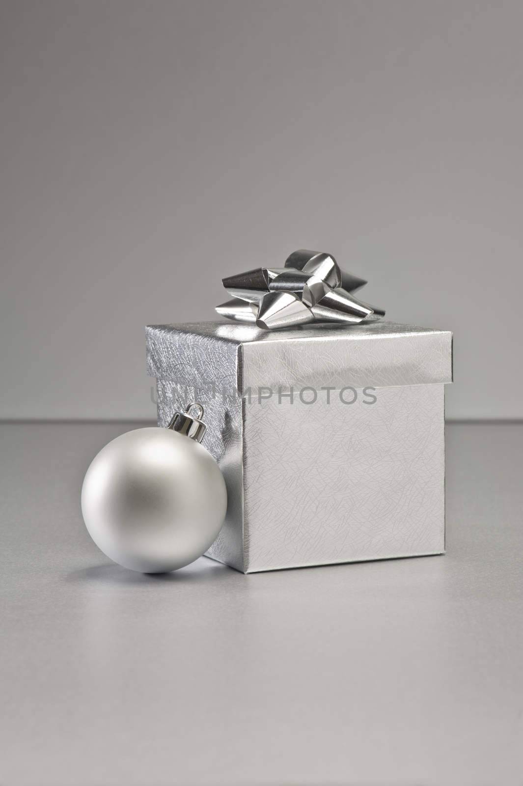 Silver bauble and present in Christmas setting