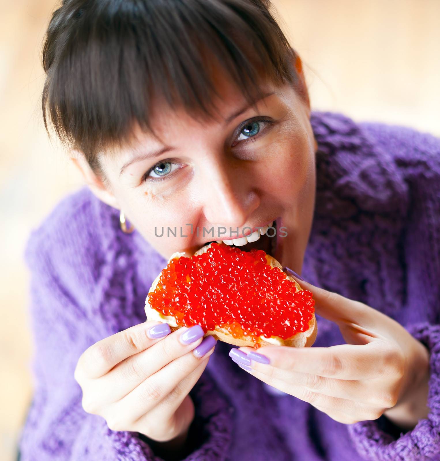  Woman eating the sandwich with red caviar 