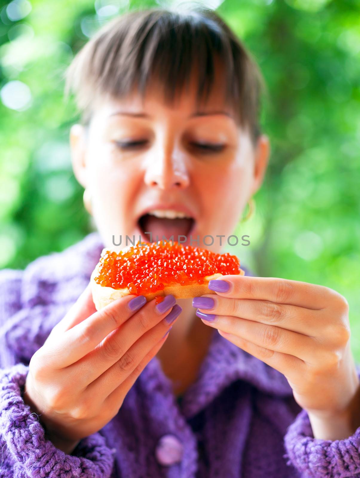  Woman eating the sandwich with red caviar  by vladimir_sklyarov