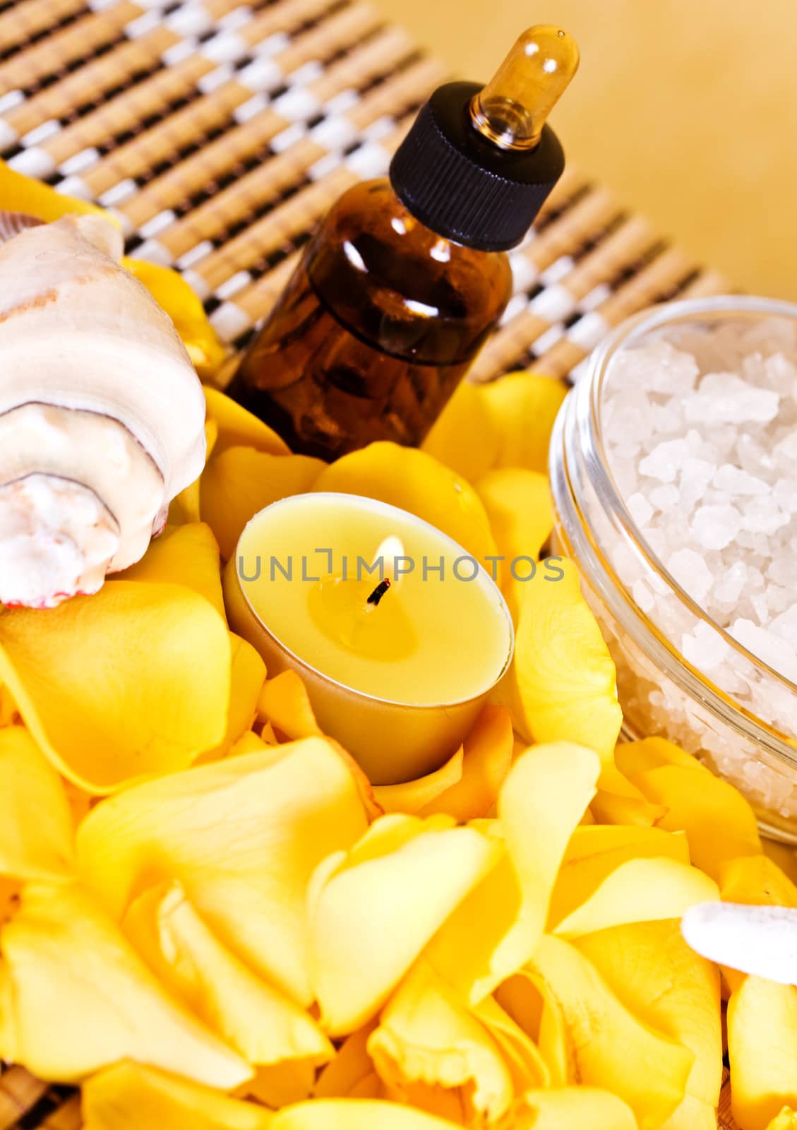 Essential oil with rose petals on wooden background