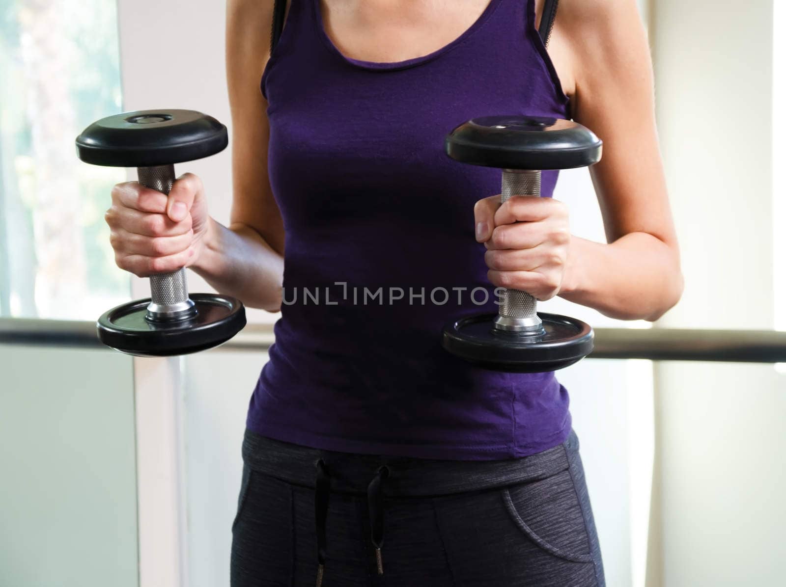 Girl training in gym - holding a dumbbells