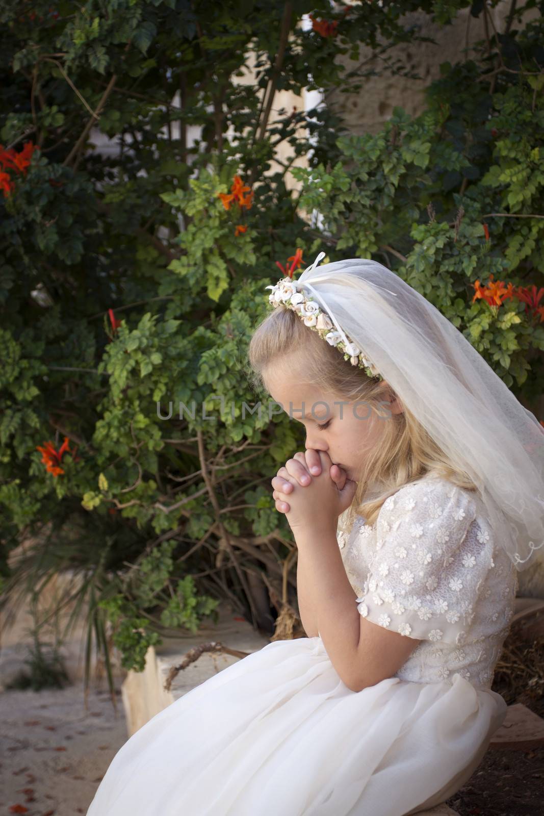A young child praying during her first holy communion