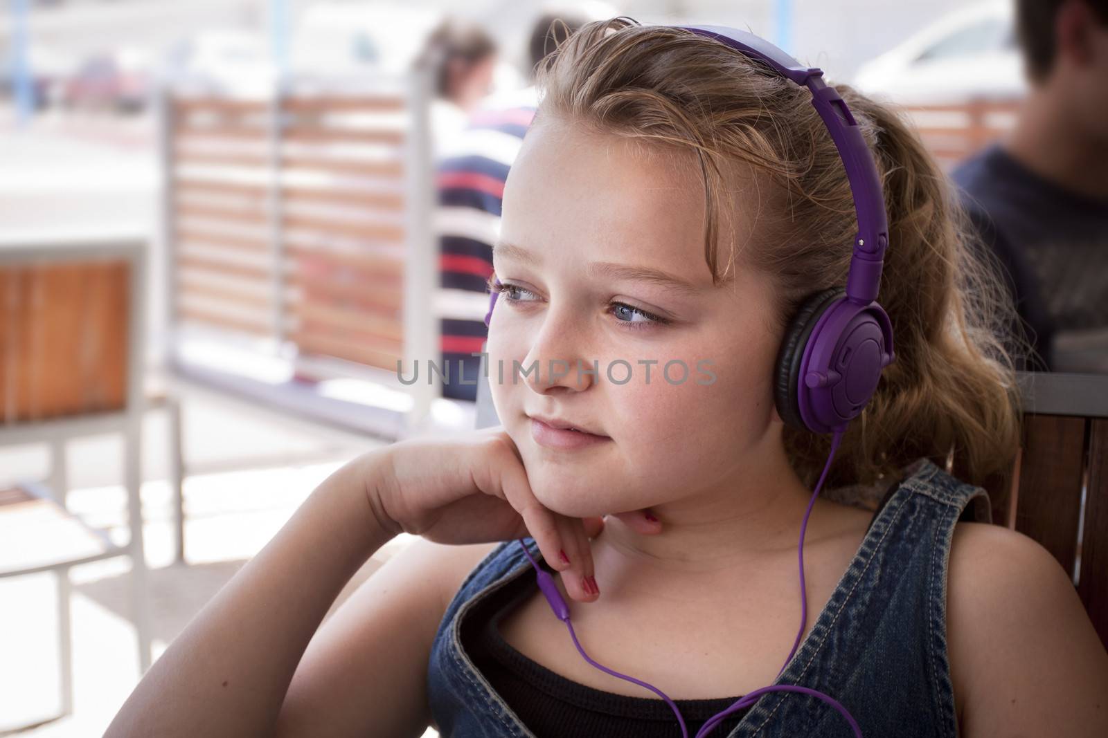 Child sitting in a restaurant listening with headphones