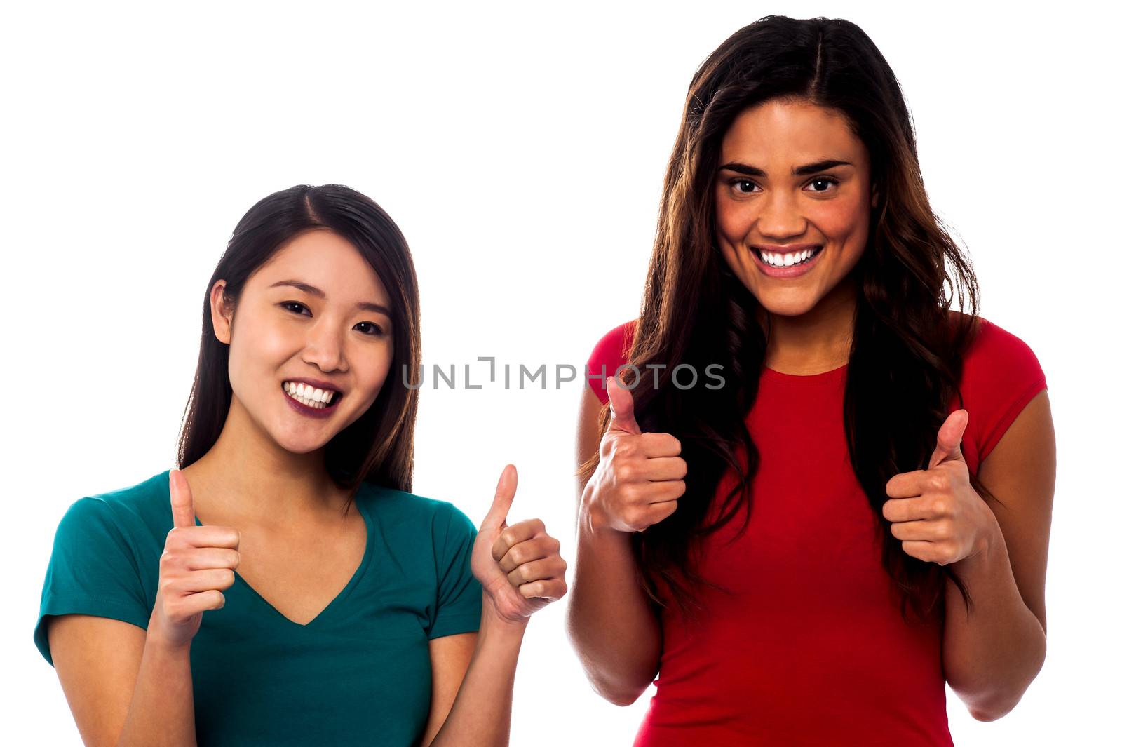 Two girls cheering up with thumbs up by stockyimages