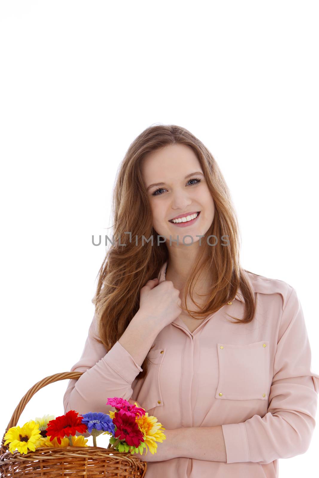 Beautiful teenage girl with fresh flowers in a wicker basket on her arm giving the camera a lovely friendly smile isolated on white