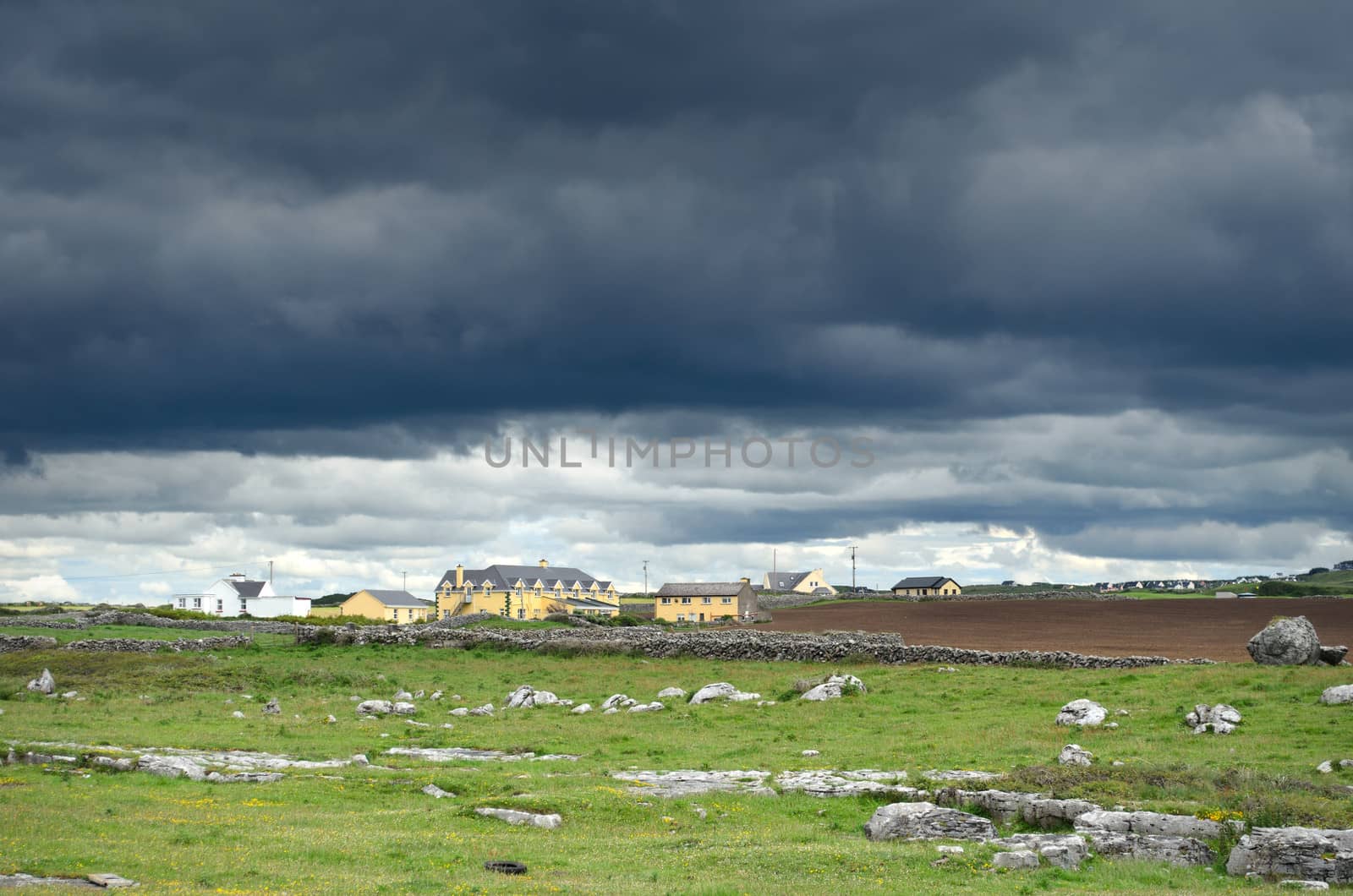 Black clouds and a stormy sky over a small town in county Clare in eastern Ireland.
