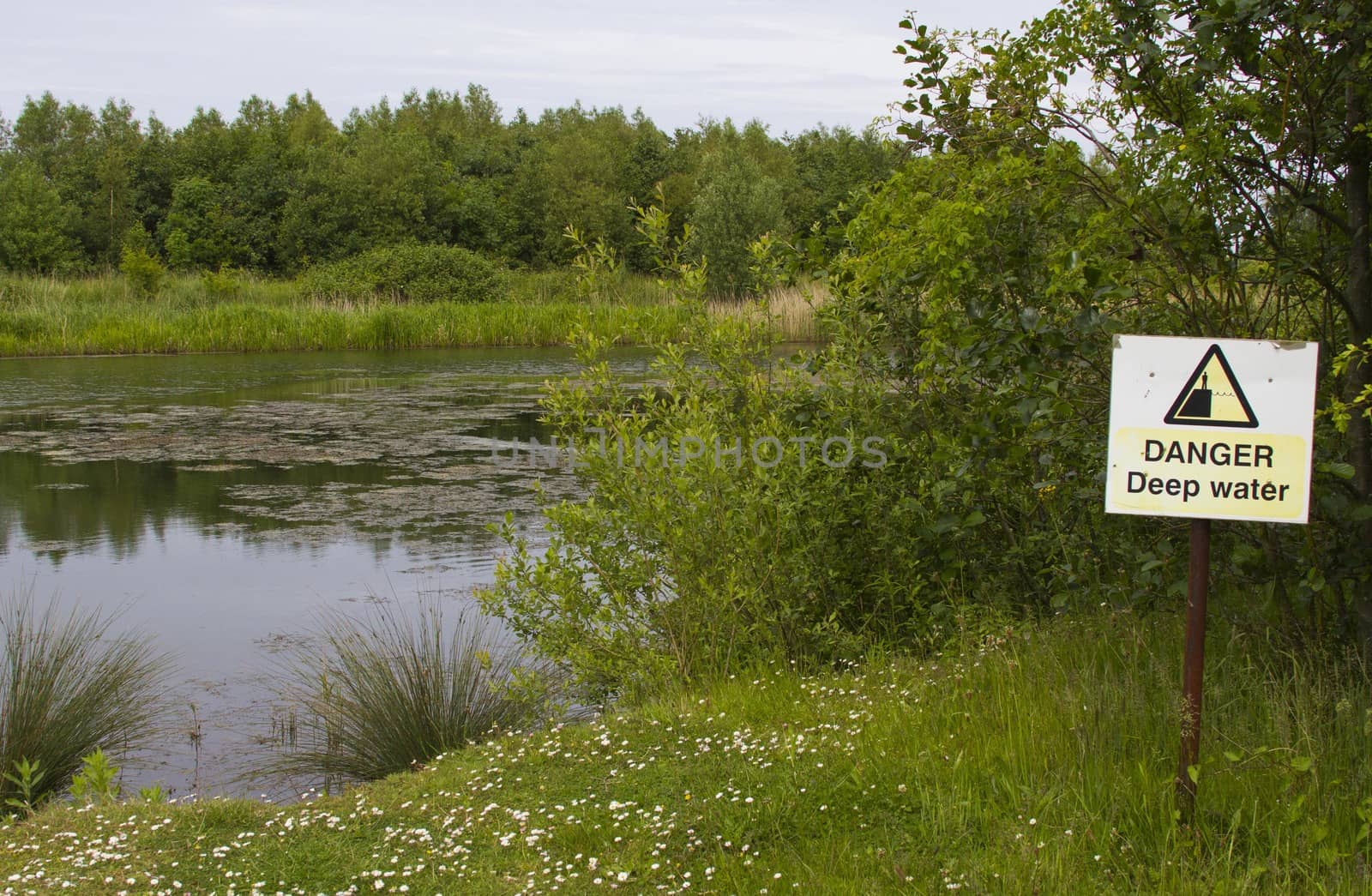 warning sign next to lake