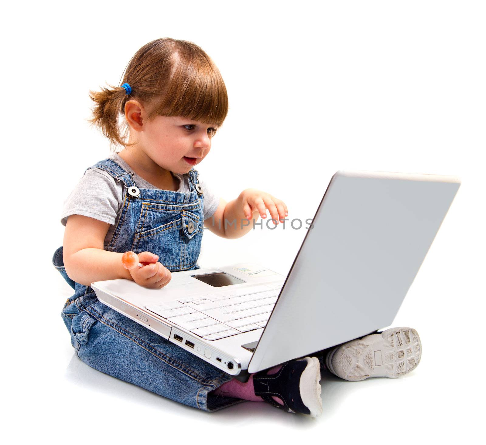 Cute little girl sitting with a laptop 