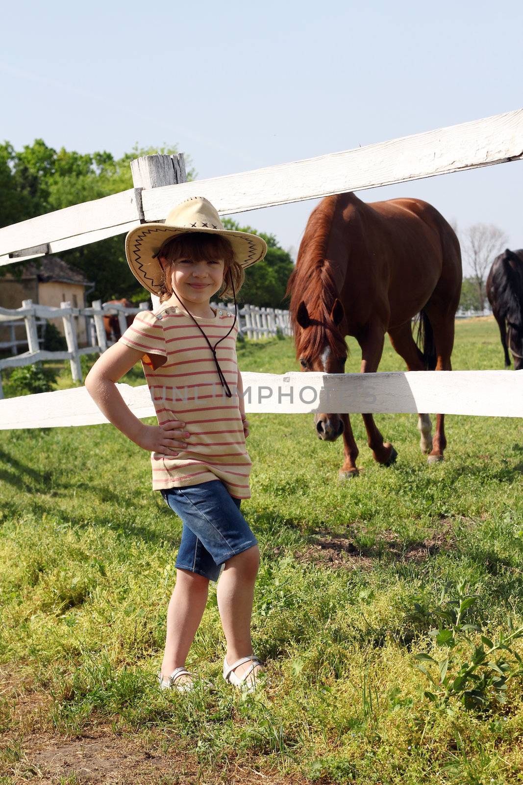 little girl with cowboy hat on ranch by goce