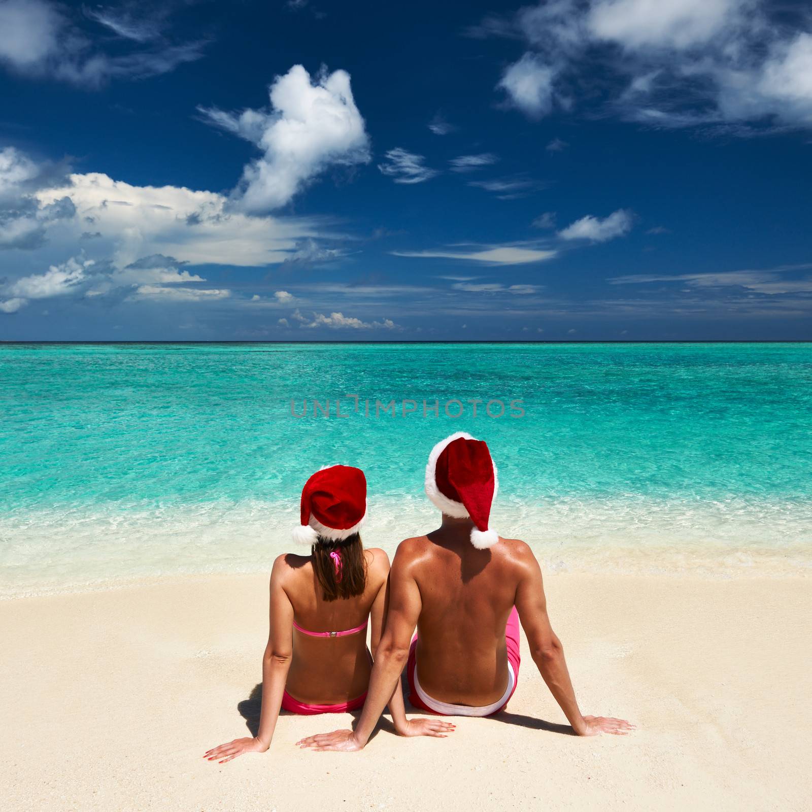 Couple in santa's hat on a beach at Maldives by haveseen