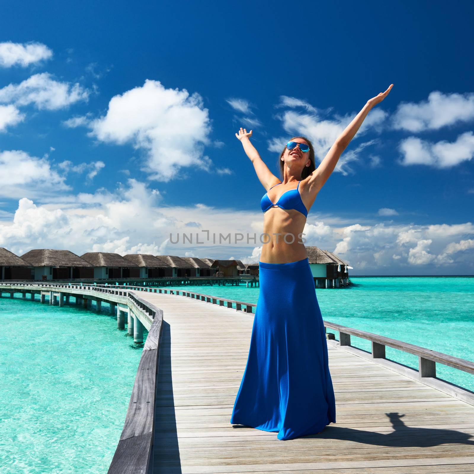 Woman on a tropical beach jetty at Maldives