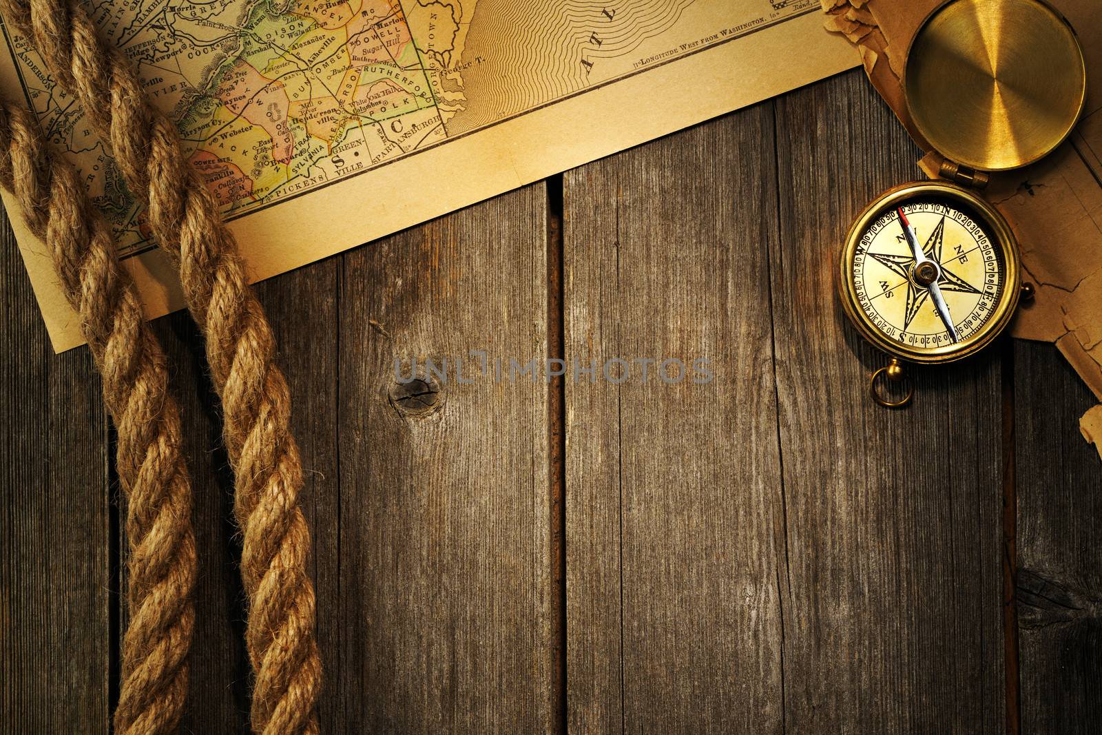 Antique brass compass and rope over old map