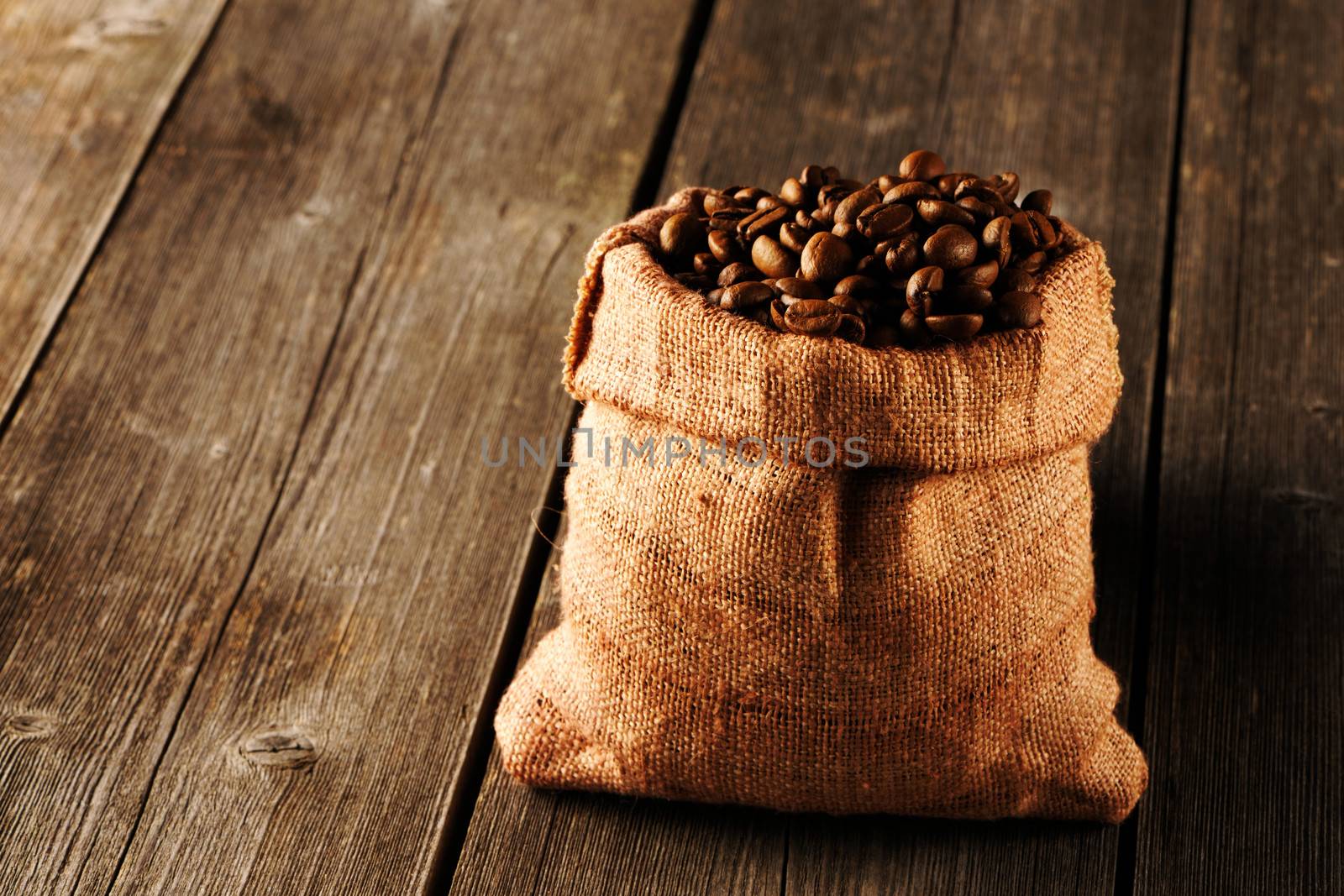 Coffee beans in bag on wooden table