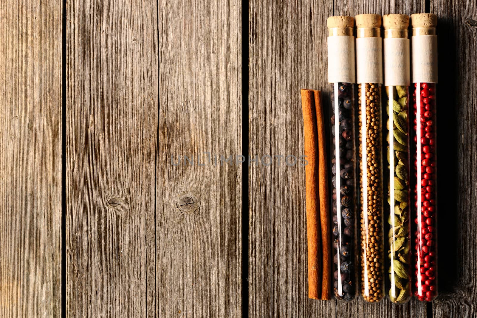 Spices in beakers on wooden background