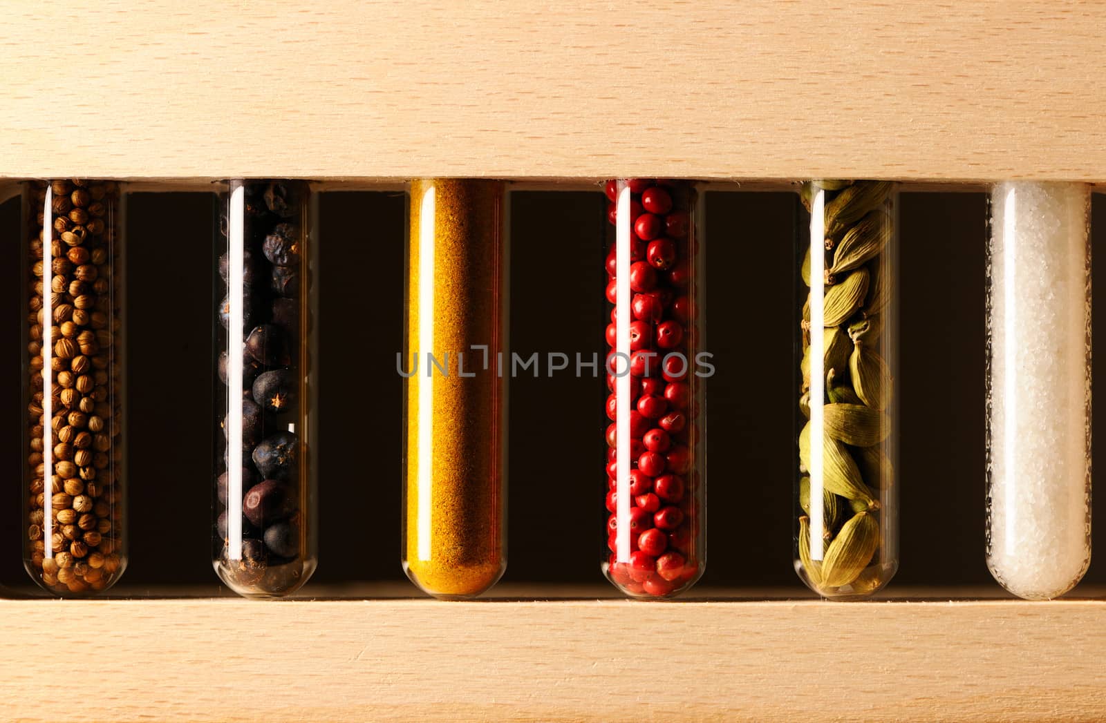 Spices in beakers against dark background