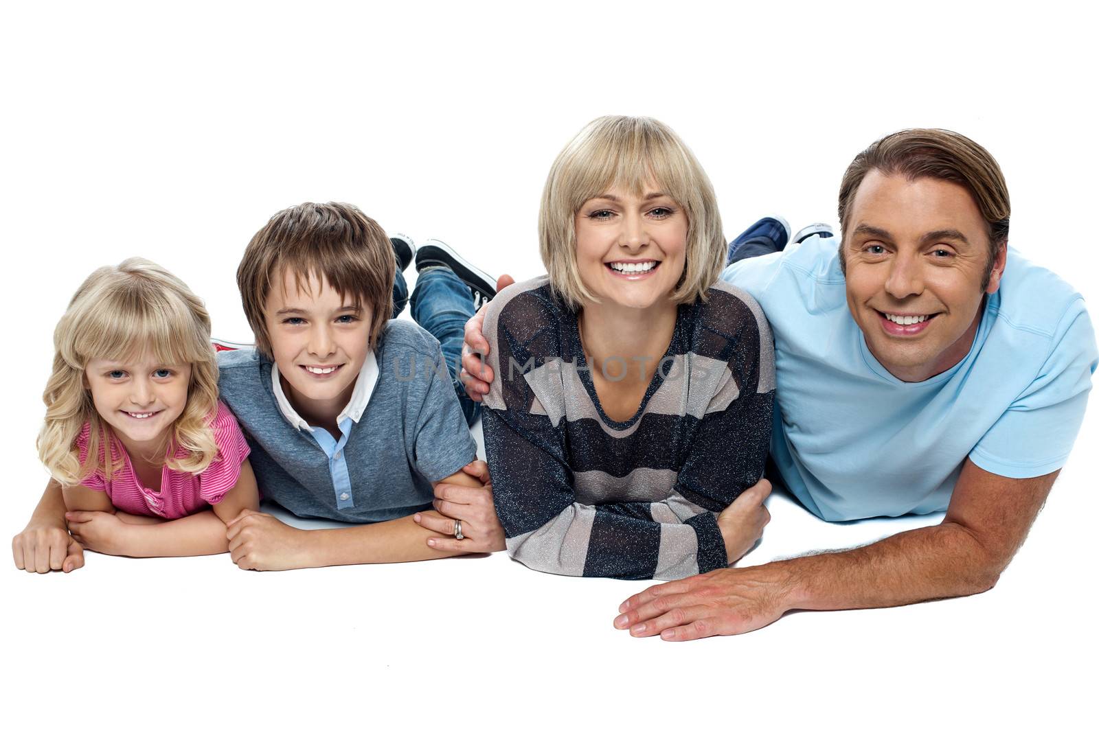 Smiling family of four lying on studio floor