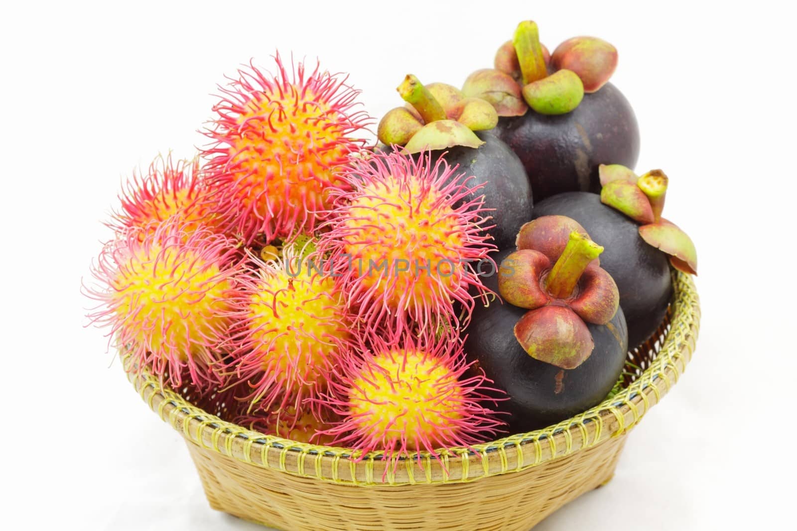 Fresh organic rambutan and mangosteen Thai fruits in wicker basket.