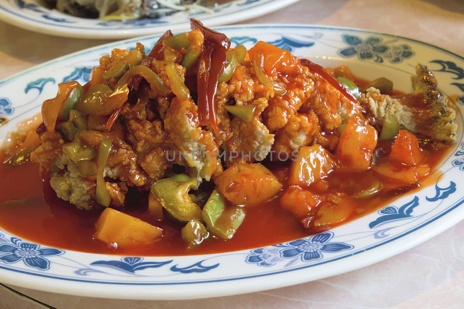 Deep Fried Whole Fish Chinese Dish with Bell Peppers Pineapple Red Ginger and Sweet and Sour Sauce Closeup