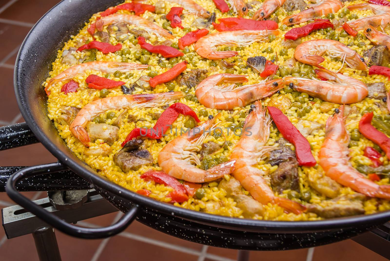 Closeup of traditional spanish paella cooked in a pan, with yellow rice and seafood