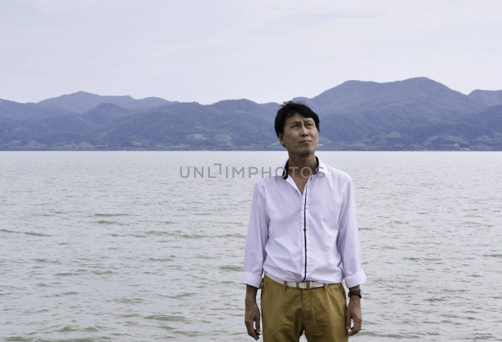 Senior Man Thinking On Beach by siraanamwong