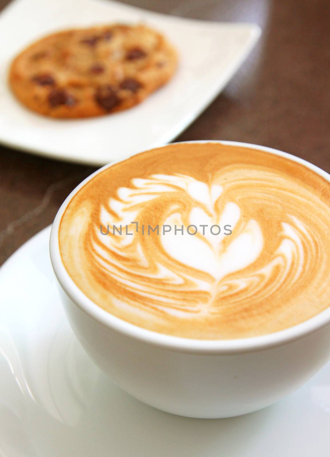 Cup of art latte on a cappuccino coffee with cookie by nuchylee