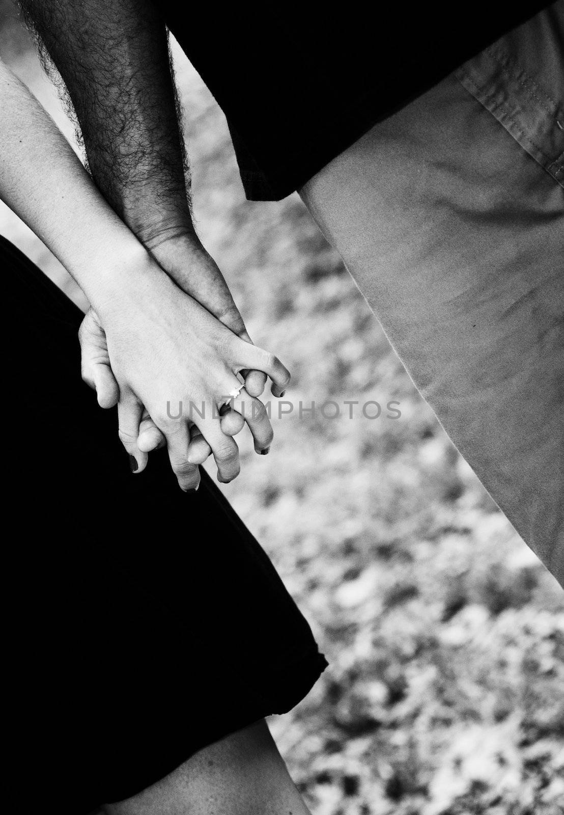 Close up picture of holding hands and engagement ring