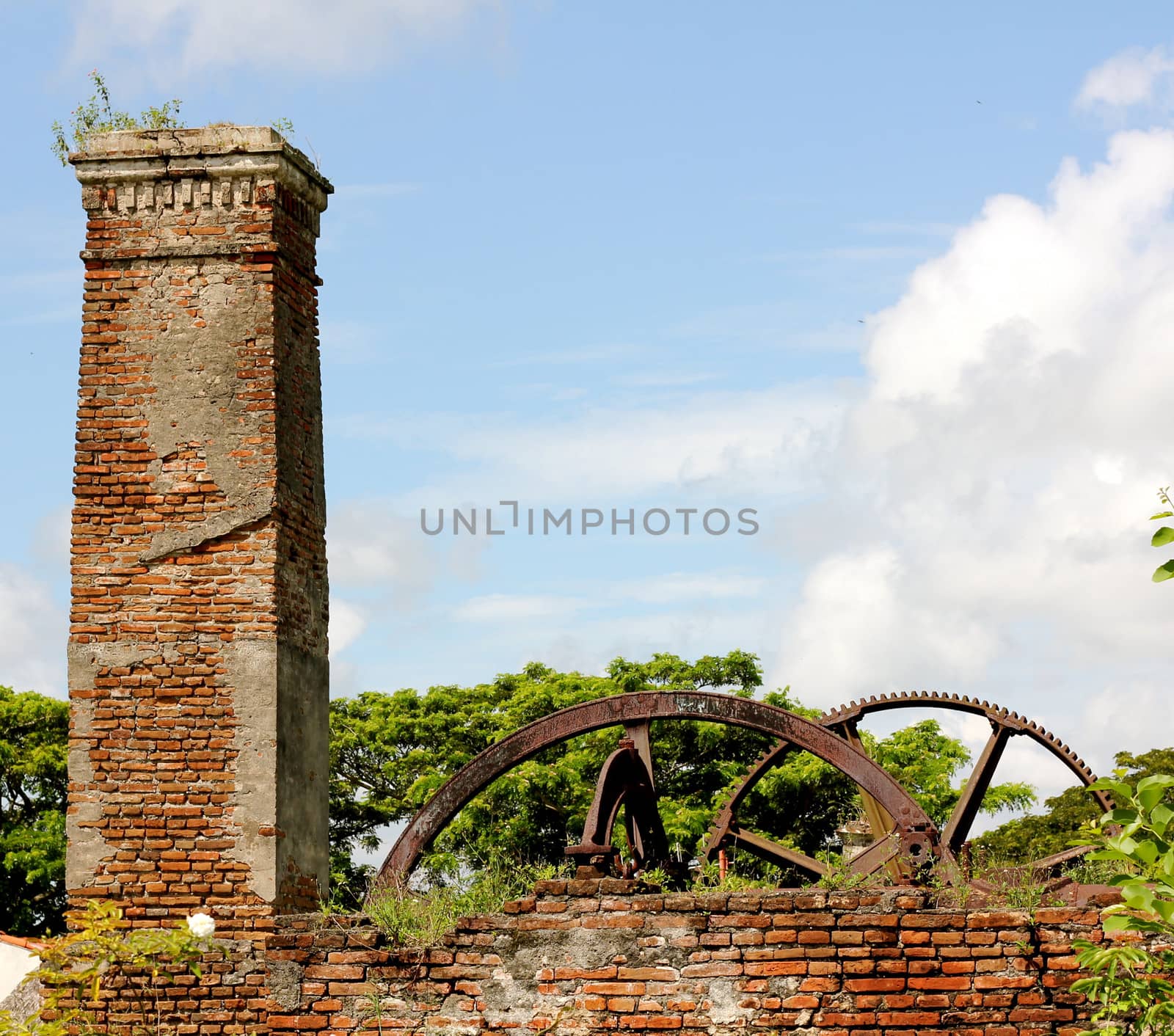 Ruins of an abandoned and overgrown sugar mill in Cuba on a sunny day.