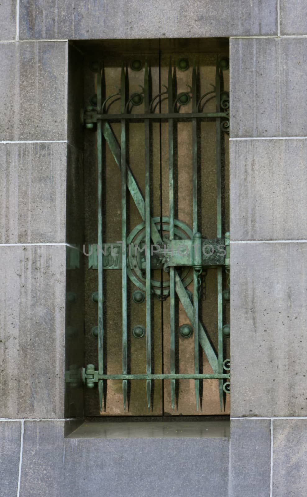 Decorative metal bars aged and weathered to a green patina, on a mausoleum window at Graceland Cemetery, Chicago, Illinois, USA